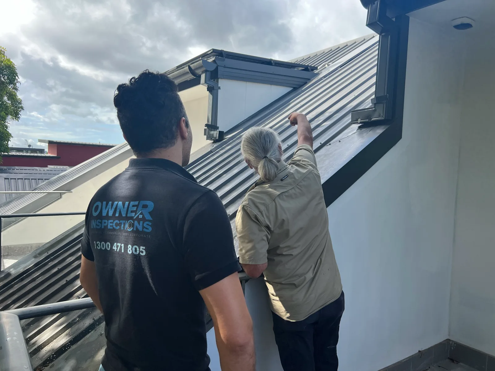 Owner Inspections inspector and builder examining metal roof sheeting and box gutter flashing during a site inspection