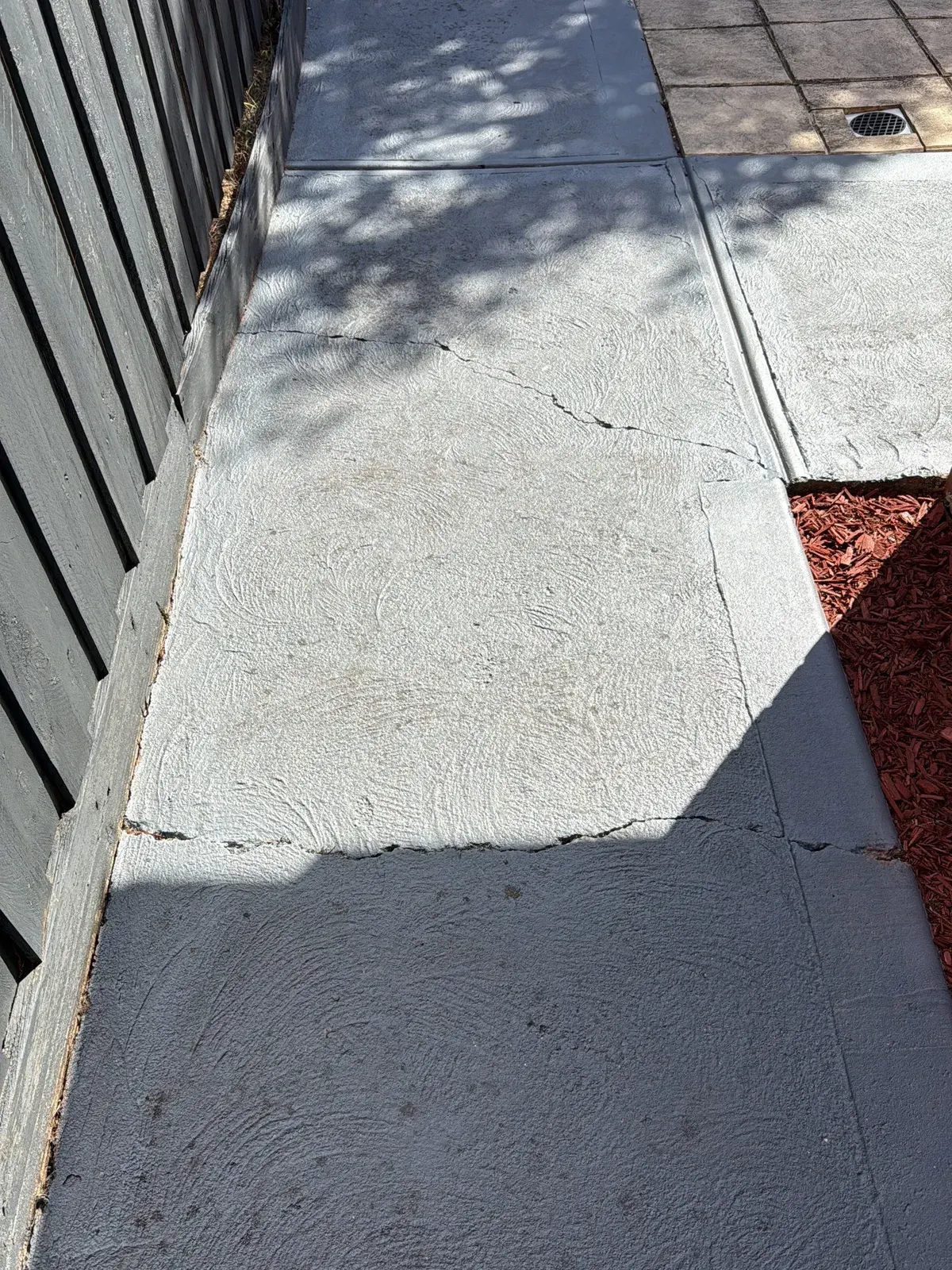 Cracks across a concrete side path beside a timber fence, recorded during a property inspection in Newport VIC