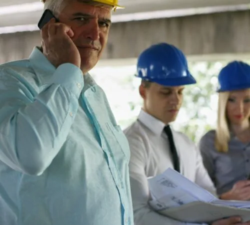 Construction dispute experts reviewing building plans on site