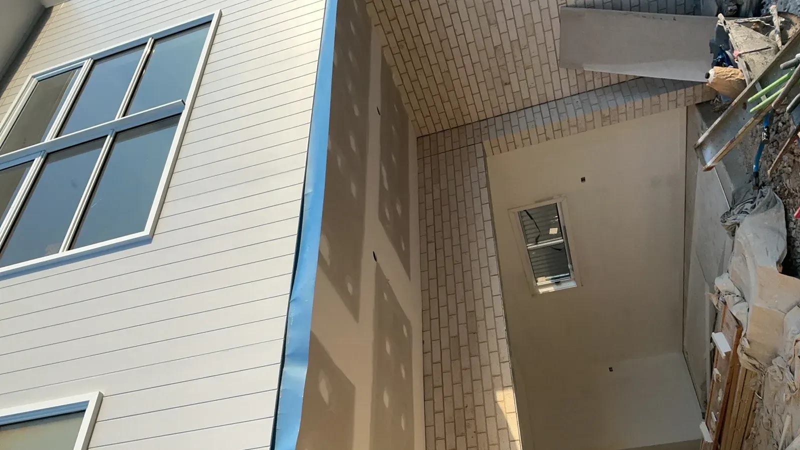 Horizontal lap cladding boards and brick on a house exterior under construction