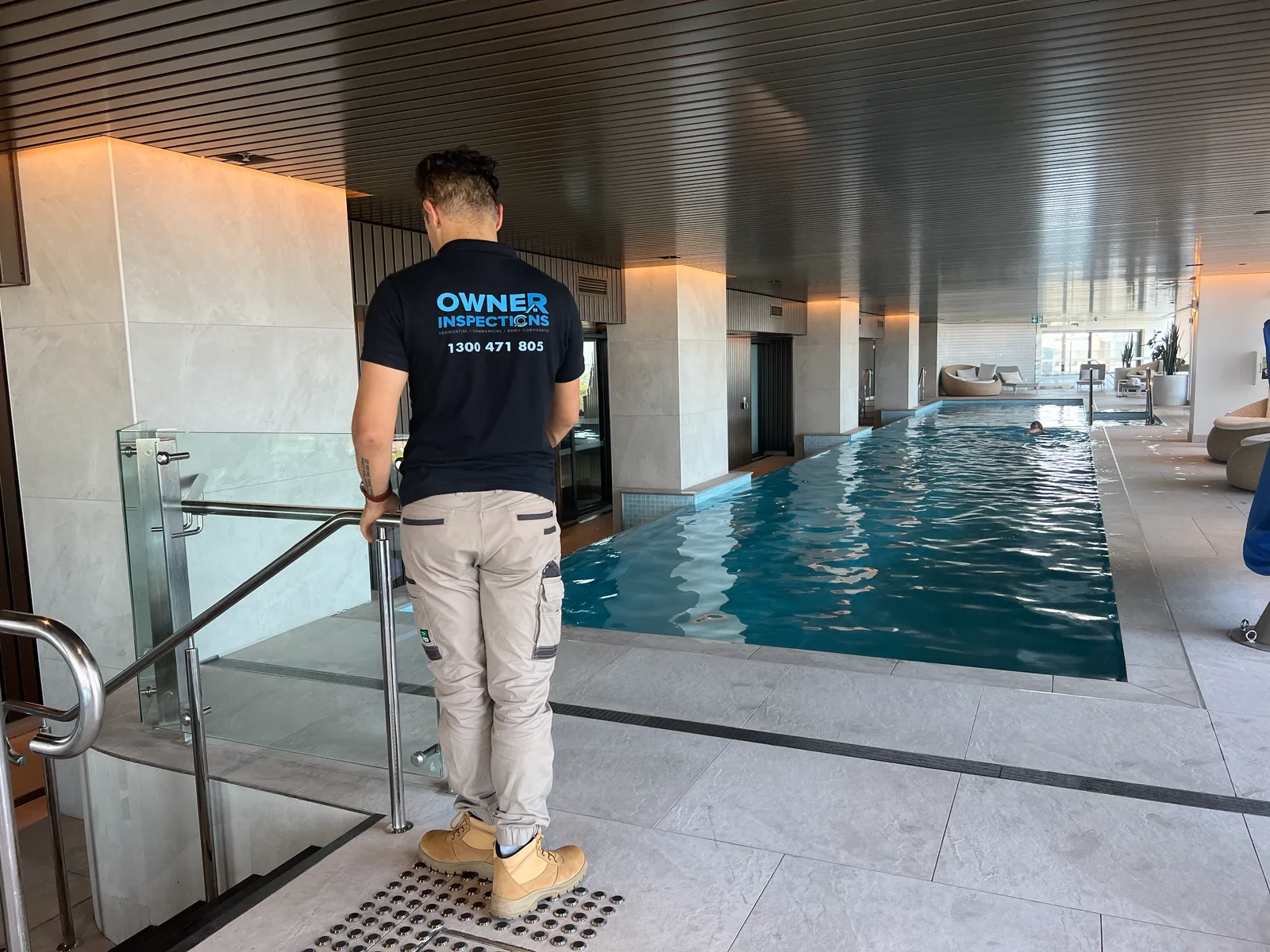Owner Inspections inspector testing a glass pool gate and its self-closing latch