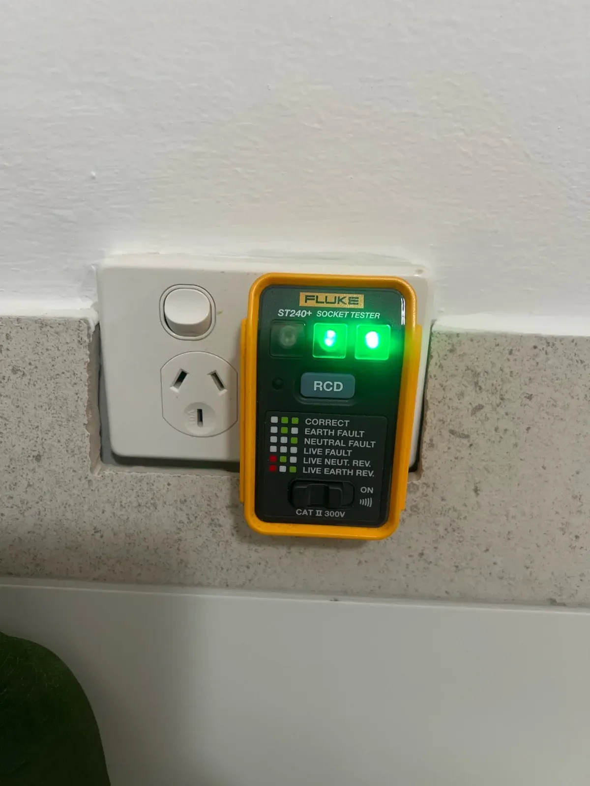 Inspector testing a power point and safety switch with a socket tester