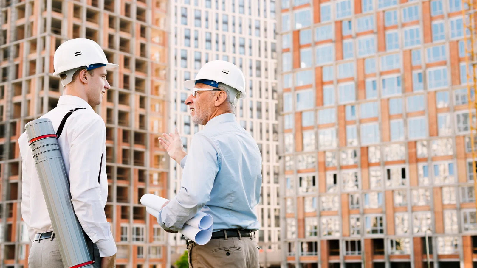 Building consultants reviewing plans in front of an apartment development, the kind of common property assessment that appears in strata records