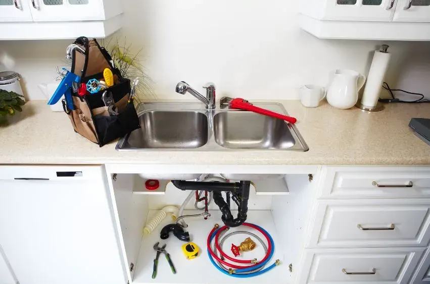 Residential plumbing pipes and fittings under a kitchen sink in an Australian home