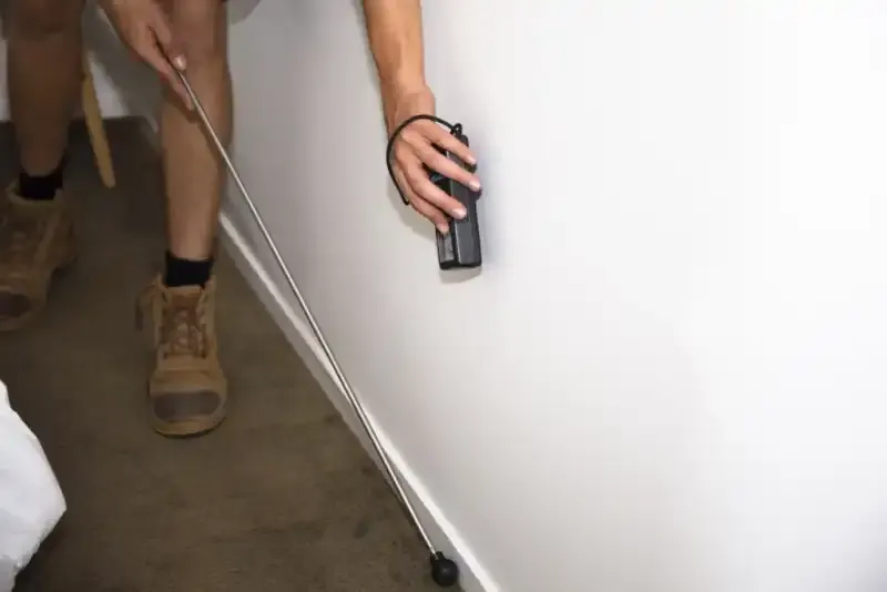 Building inspector using thermal imaging to detect pest activity during a property inspection in Australia